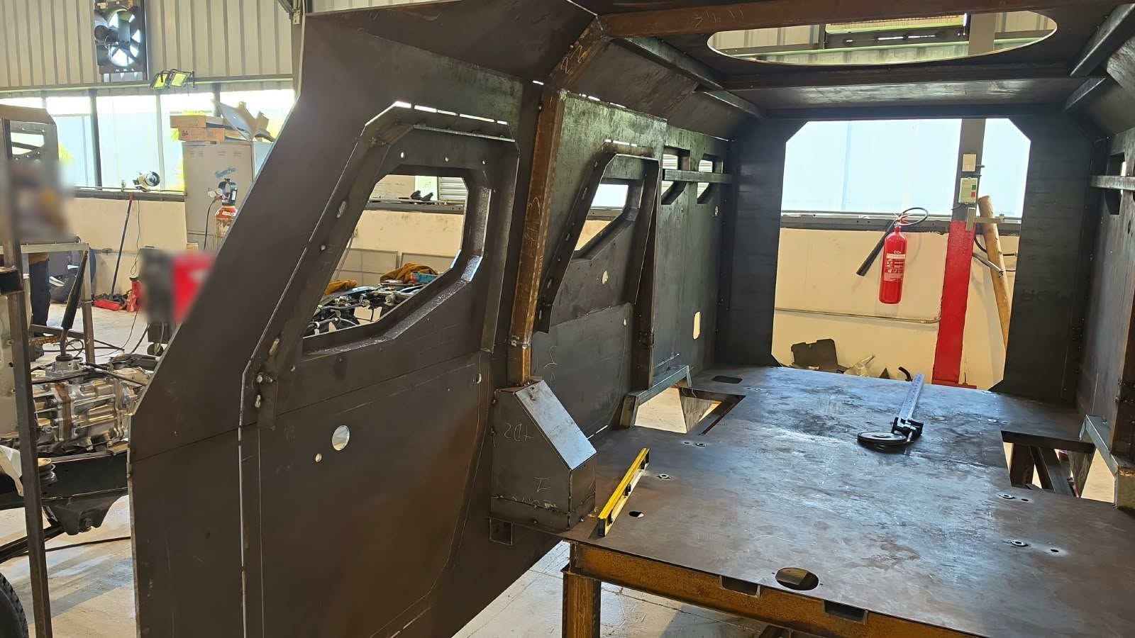Estructura interior de acero de una cabina blindada en fabricación, con puerta de acero y ventana ya instaladas
